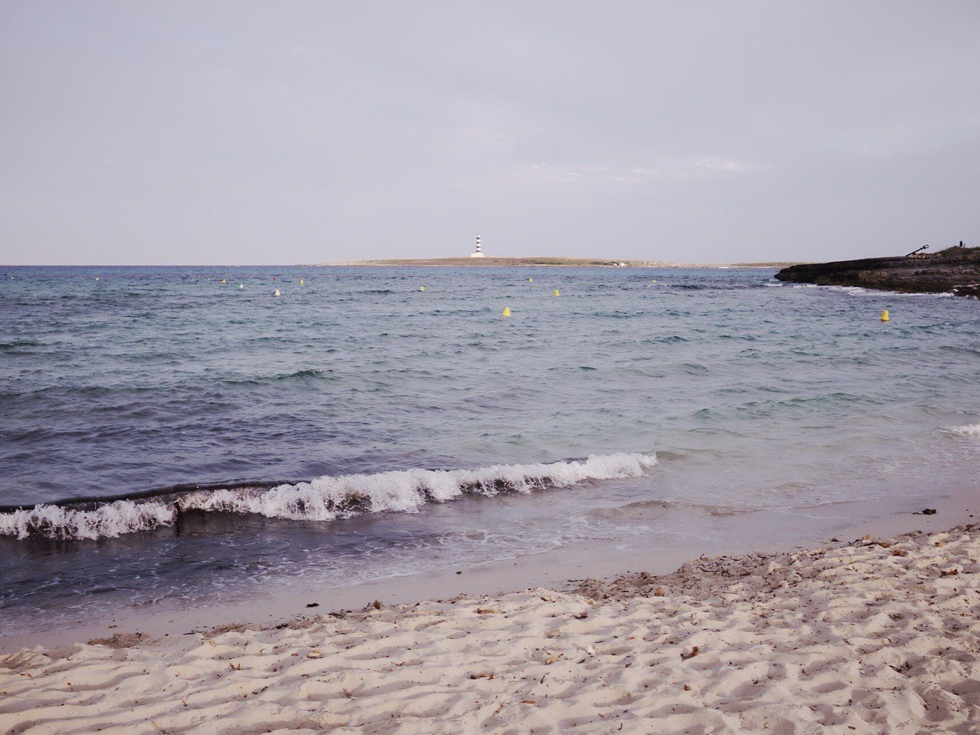 La spiaggia di Punta Prima con il faro dell’Illa de l’Aire sullo sfondo